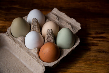 Caja de huevos de granja orgánicos libre pastoreo varios colores ordenados vistos desde arriba inclusión razas