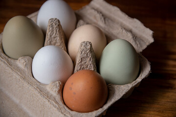 Caja de huevos de granja orgánicos libre pastoreo varios colores ordenados vistos desde arriba inclusión razas close up