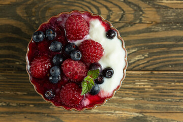 raspberries and blueberries in yogurt sauce in kremanka, top view. Juicy raspberries and blueberries. High quality photo