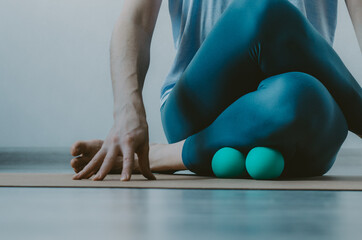 Person doing yin yoga and myofascial release on shin muscle. Concept: self-care practices at home, SMFR, myoyin