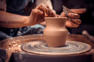 Fototapeta na wymiar Creating a jar or vase. Master crock. Making clay jug. The sculptor in the workshop makes a jug out of earthenware closeup. Potter's wheel. Pottery concept.