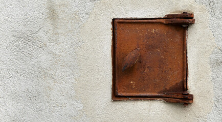 rusty oven door in a plastered wall