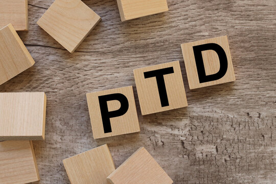 PTD. text on wooden blocks on a wooden background