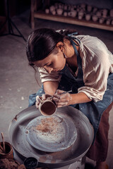 Beautiful craftsman master works with clay on a potter's wheel. Inspiration and creativity.