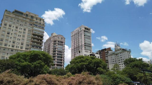 Meu S&atilde;o Paulo, Brazil - 11-27-2021: Residencial Buildings View from Parque do Povo (People&acute;s Park). Blue Sky with clouds and big trees