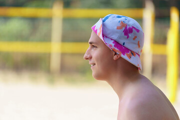 Summer portrait of a young man in sun hat. Side view