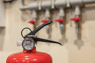 Manual fire extinguisher on the background of high pressure compressed air taps.