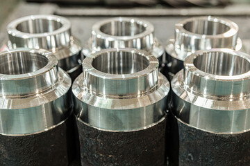 Billets of transition bushings on a rack after turning and milling.