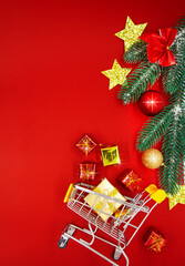 christmas background with decorations, shopping cart on red background, copy space. 