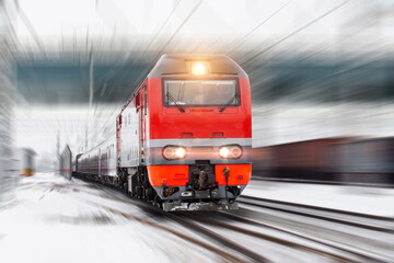 Winter landscape on a high-speed railway road, a racing locomotive with passenger wagons.