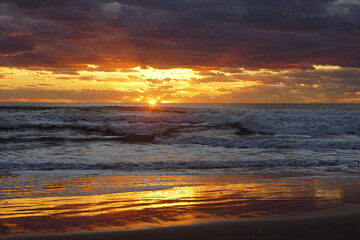Fototapeta na wymiar golden reflections in the sunset on the shore