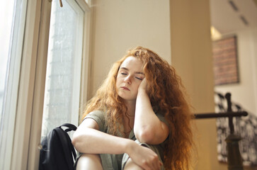 Fototapeta na wymiar tired young woman in a school corridor