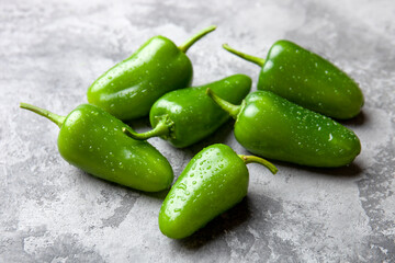 Ripe jalapeno  or pepperoni on kitchen table. Closeup view of green chili pepper. Hot spice