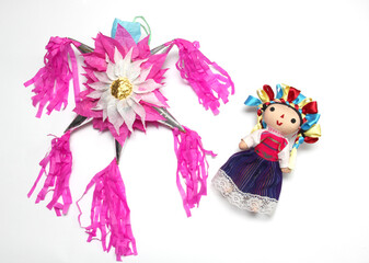 Obraz na płótnie Canvas Mexican handmade piñata of clay and colored paper to celebrate posadas and Christmas with doll, canes and poinsettia flowers 