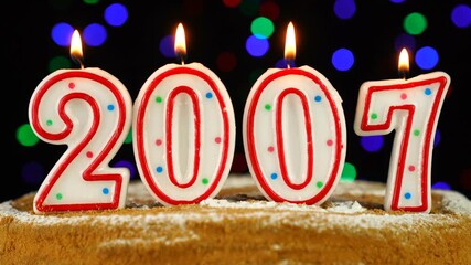 Birthday cake with white burning candles in the form of number 2007