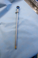 an endoscopy optic for performing an abdominal endoscopy lies on a blue base