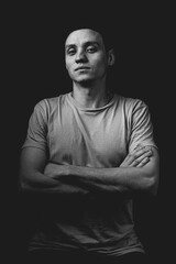 Handsome guy posing in studio on isolated black background. Studio portrait with one light source.