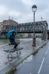 Paris, France - 11 27 2021: A woman walking in the rain along the docksfdeli