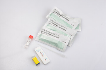 isolated shot of a negative result rapid express antigen antibody coronavirus covid-19 pandemic test sample, blood collector pastette, lancet vial, solution, packages on white background