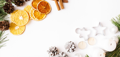 Christmas Banner. winter, new year composition. Fir tree branches, pine cone, candles, cinnamon sticks, dried oranges, gingerbread on white background. Flat lay, top view, copy space