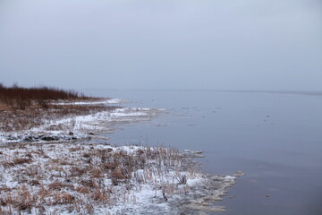 winter landscape lake shore covered with snow water covered with thin ice