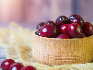 large cranberries in a wooden bowl on a wooden background. Healthy food and nutrition. Place for text.