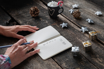 Writing a To do list on christmas holidays decorated desk