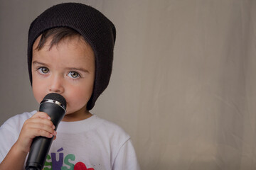 Little boy singing rap with microphone