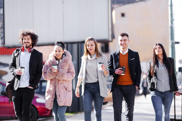 Fototapeta premium Group of people walking on a street with confidence. Businessmen and businesswomen traveling together..