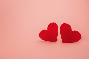 Valentine's day concept banner with two felt red hearts on pink background. Place for your text.  Festive background.Selective focus.