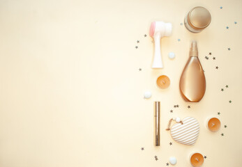 Accessories for spa treatments, body and face care and makeup. Lotions, creams, cotton pads, cotton flowers, mascara, a wash brush on a beige background. Flat lay.