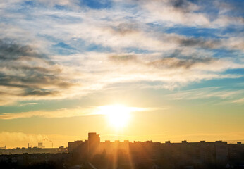 Morning sunrise over the city on a background of sky with clouds