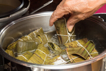 Traditional Venezuelan cuisine for the December festivities, hands preparing Hallacas. Typical dish of ancient traditions where a mixture of ingredients are wrapped in banana leaves