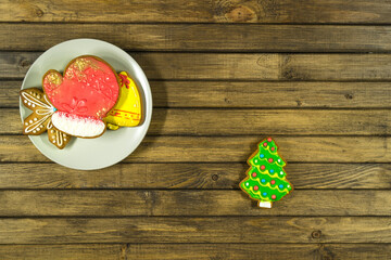 Gingerbread cookies on plate at wooden background. Christmas pattern with copy space.