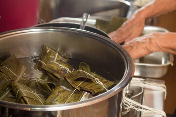 Traditional Venezuelan cuisine for the December festivities, Hallacas boiling in a pot. Typical dish of ancient traditions where a mixture of ingredients are wrapped in banana leaves