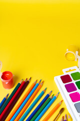 Naklejka premium bright colored pencils and paints for drawing on a yellow background, the concept of creativity and inspiration. High quality photo