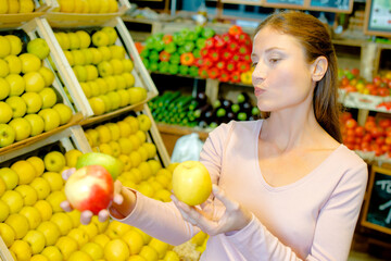woman choosing apples at supermarket