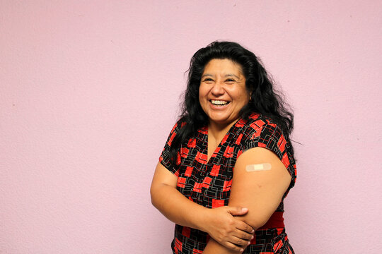 Body positive overweight adult laina woman shows her arm recently vaccinated against Covid-19 in the new normal for the Coronavirus pandemic
