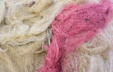 Close up, close up view and background of used brown and red fishing nets laid one on top of the...