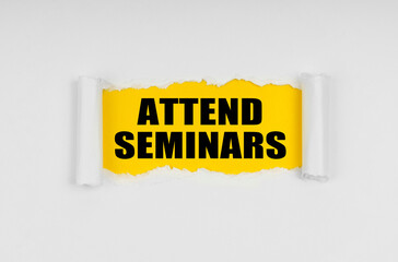 A window is made in the paper, where on a yellow background the inscription - Attend Seminars