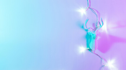 Deer lights neon Christmas winter background. Minimal abstract xmas reindeer. Holiday decoration bauble ball on neon gradient backdrop. Minimal new year card.