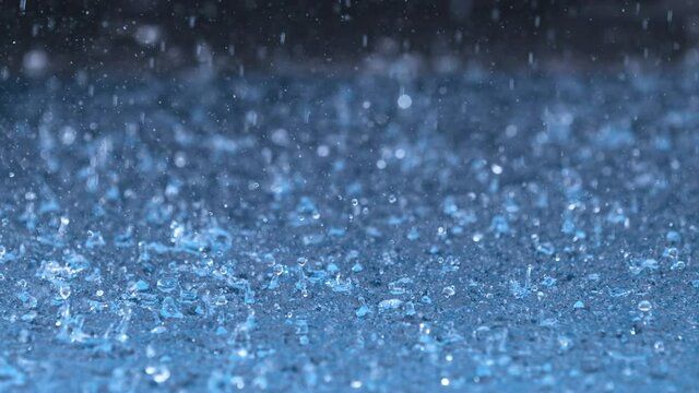 Super Slow Motion Shot of Droplets Raining on Blue Water Surface at 1000 fps.