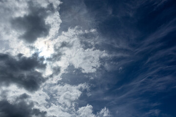 Sun shining on stormy sky with heavy cloudscape background. Skyscape natural heavenly scenery in summertime above sea