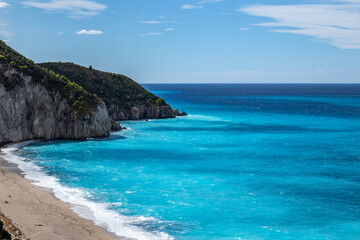 Azure vibrant waves on coast of Lefkada island. Mylos sandy beach in Greece. Summer nature vacation travel to Ionian Sea