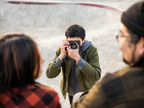 Young Indigenous male photographer, non-binary skater and father outdoors