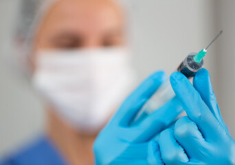 Doctor prepares the syringe for vaccination