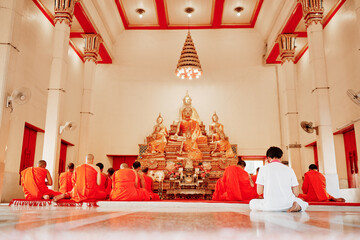 Buddhist monks kneels down prayer in temple Wat Chalong, Phuket, Thailand.