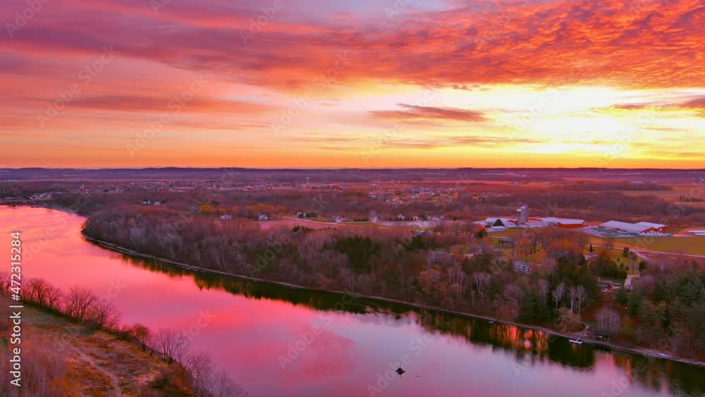 Wall mural perfect slow panning view of tranquil water reflecting sunrise with red clouds and colorful sky. thi