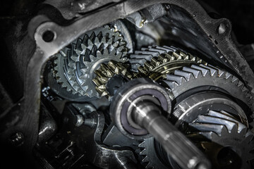 Car transmission, gearbox with visible gears and cogs in the garage.