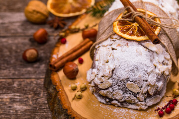 Christmas Holiday Background. Stollen, German Christmas Cake with Dried Fruits and Sliced Almonds Nuts. Selective focus.